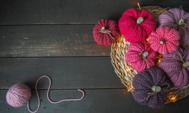 Koyu kahverengi ahşap zemin üzerinde pembe örgü balkabakları