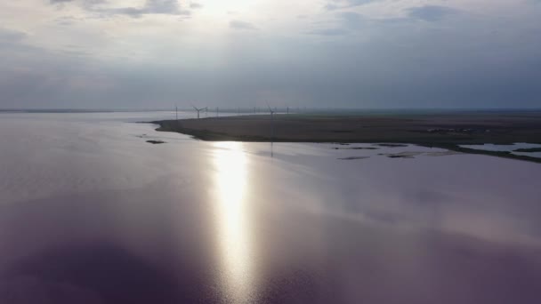 Gün Batımında Güzel Pembe Bir Gölün Kıyısında Rüzgar Jeneratörleri Kıyıda — Stok video