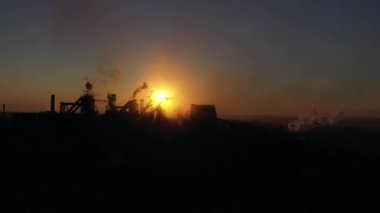 Güneş ışığının arka planına karşı patlama fırınlarının silueti. Hava aracı görüntüsü. Hava kirliliği kavramı
