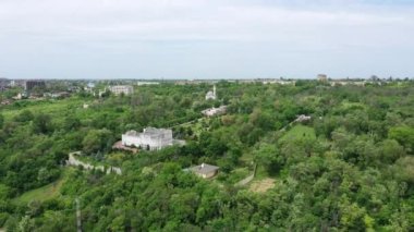 Şehrin panoramik manzarası. Ağaçların arasındaki şehir binaları. Ukrayna 'nın Mariupol kenti Azov Denizi kıyısında yer almaktadır. Drone bakış açısı.
