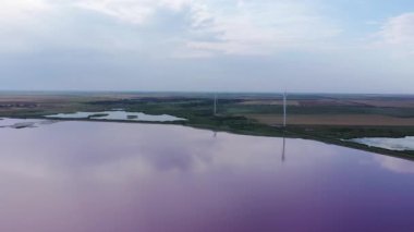 Pembe gölün kıyısındaki yel değirmenleri. Akşam vakti. Hava görüntüsü. Ukrayna 'nın Kherson bölgesi
