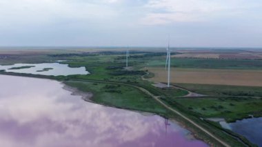 Pembe gölün kıyısında rüzgar jeneratörleri var. Akşamları hava manzarası. Lemurian Gölü - Ukrayna 'nın Kherson bölgesinde bir göl
