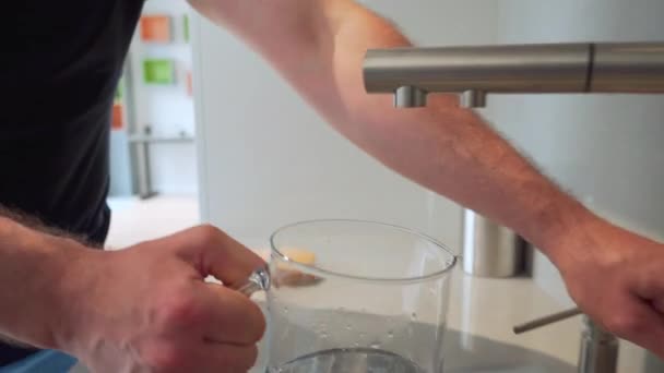 Ο άνθρωπος ανοίγει βρύση βρύση και γεμίζουν κανάτα με καθαρό νερό σε φωτεινό κουζίνα. Κλείσιμο — Αρχείο Βίντεο