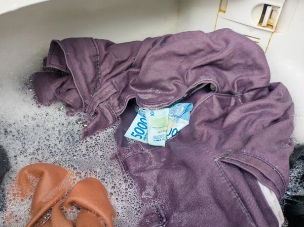 洗濯機で洗浄されているズボンのポケットにインドネシアのお金50 000ルピア 資金洗浄イラストのために — ストック写真