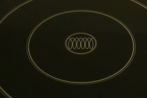 The symbol of the induction cooker on the ceramic surface of the stove.
