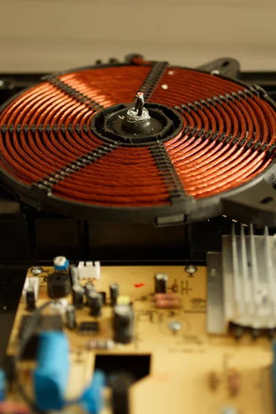 İndüksiyon fırınının elektromanyetik spirali. İndüksiyon düdüklü tencere parçaları. İndüksiyon fırını için ısıtma elementi. Bir indüksiyon fırınının ısıtma bobini.