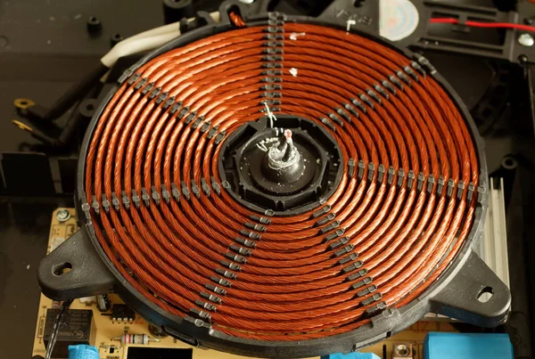 İndüksiyon fırınının elektromanyetik spirali. İndüksiyon düdüklü tencere parçaları. İndüksiyon fırını için ısıtma elementi. Bir indüksiyon fırınının ısıtma bobini.