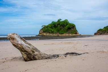 Pasifik Okyanusu kıyısındaki boş Kosta Rika plajı. Dalgalar kumun üzerinde, yemyeşil tropikal adaları var.