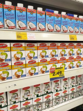 KUALA LUMPUR, MALAYSIA - 12 Haziran 2021: Ticari paketleme ve süpermarketlerde sergilenen işlenmiş hindistan cevizi sütü üzerine odaklanmış. Markaya göre sıralanmış ve fiyat etiketi var..