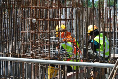MALACCA, MALAYSIA -16 Mayıs 2016: Malezya 'daki inşaat alanında çelik takviye barı üreten inşaat işçileri. Destek çubuğu küçük bir kabloyla birbirine bağlanmış.. 