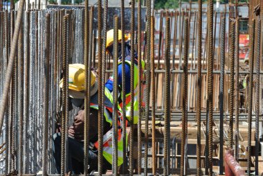 MALACCA, MALAYSIA -16 Mayıs 2016: Malezya 'daki inşaat alanında çelik takviye barı üreten inşaat işçileri. Destek çubuğu küçük bir kabloyla birbirine bağlanmış.. 
