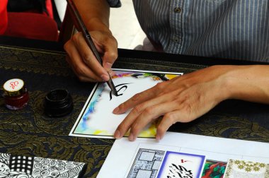 PUTRAJAYA, MALAYSIA - NOVEMBER 01, 2015: İnsanlar Putrajaya, Malezya 'da düzenlenen İslam Festivali sırasında Arapça kaligrafi çiziyor. 