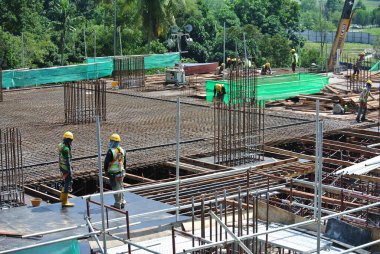 SERDANG, MALAYSIA -13 Mayıs 2016: Serdang, Malezya 'daki şantiyede çalışan inşaat işçileri. Güvenli bir şekilde çalıştıklarından emin olmak için gerekli güvenlik ekipmanlarını giyiyorlar..  