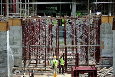 SERDANG, MALAYSIA -13 Mayıs 2016: Serdang, Malezya 'daki şantiyede çalışan inşaat işçileri. Güvenli bir şekilde çalıştıklarından emin olmak için gerekli güvenlik ekipmanlarını giyiyorlar..  
