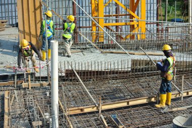 MALACCA, MALAYSIA -16 Mayıs 2016: Malezya 'daki inşaat alanında çelik takviye barı üreten inşaat işçileri. Destek çubuğu küçük bir kabloyla birbirine bağlanmış..