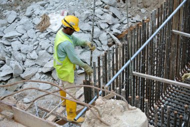 MALACCA, MALAYSIA -16 Mayıs 2016: Malezya 'daki inşaat alanında çelik takviye barı üreten inşaat işçileri. Destek çubuğu küçük bir kabloyla birbirine bağlanmış..