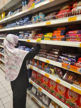 KUALA LUMPUR, MALAYSIA -14 Haziran 2021: Bisküvilerin çeşitliliği iyi ve ilginç paketleme ve mağazanın içindeki raflarda sergilendi. Müşterilerin satın almasını kolaylaştırmak için markaya göre sırala.