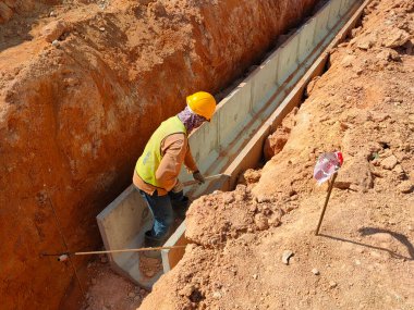 SELANGOR, MALAYSIA 20 HAZİRAN 2021: inşaat alanında yeraltı drenajı inşa eden işçiler. Sel baskınlarını önlemek için fırtına suyunu kanalize etmek için kullanılır.. 