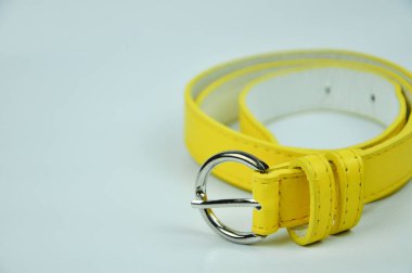 Beyaz arka planda izole edilmiş sarı kemer. Bel kemeri PU derisinden yapılmış.. 