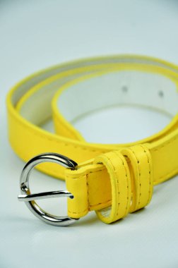 Beyaz arka planda izole edilmiş sarı kemer. Bel kemeri PU derisinden yapılmış.. 