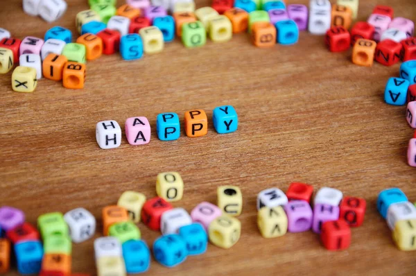 Λέξη Happy Τυπώνεται Μικρούς Πλαστικούς Κύβους Και Περιβάλλεται Από Πλαστικά — Φωτογραφία Αρχείου
