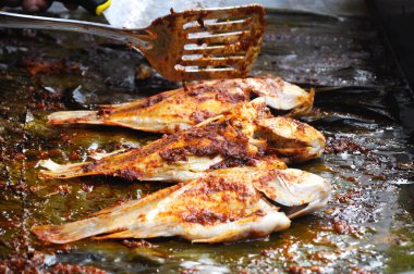 Tavada acı soslu ızgara balık. Muz yaprağıyla sar