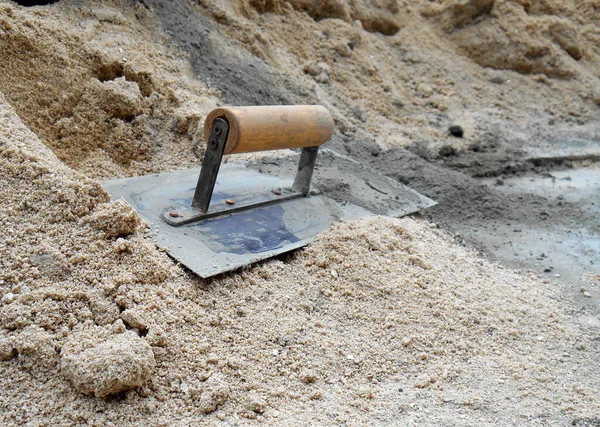 在建筑工地的沙地上用水泥砂轮作抹灰工作 — 图库照片