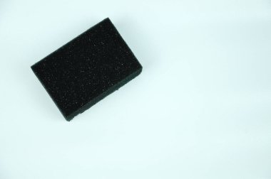 Bulaşık yıkamak için kullanılan siyah sünger. İki yüzeyi pürüzsüz ve pürüzsüz..