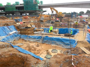 SELANGOR, MALAYSIA - 14 Mayıs 2016: İnşaat işçileri inşaat alanında yığınla çelik takviye çubuğu ve kereste formu üretiyor.  