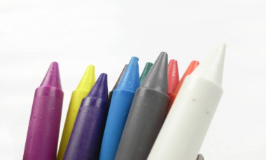 Renkli çocuklar, beyaz arka planda izole edilmiş yeşil kovada boya çubukları..  