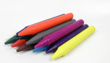 Renkli çocuklar, beyaz arka planda izole edilmiş yeşil kovada boya çubukları..  