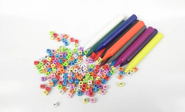 Bunte Kindermalstifte Und Kleine Bunte Plastikblöcke Mit Aufgedrucktem Alphabet Isoliert — Stockfoto