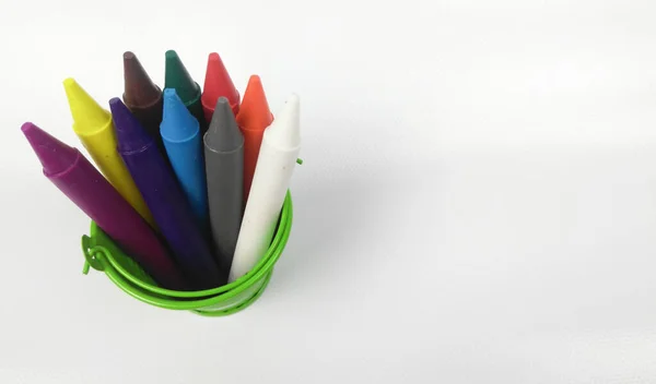 色彩斑斓的蜡笔粘在绿色的水桶里 与白色背景隔离 — 图库照片