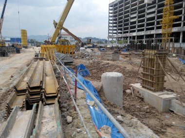 JOHOR, MALAYSIA -16 HAZİRAN 2015: Yığınla takviye çubuğu ve Johor, Malezya 'daki inşaat alanında kazılan kazılar. 