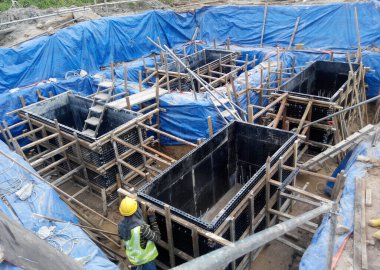 JOHOR, MALAYSIA -16 HAZİRAN 2015: Yığınla takviye çubuğu ve Johor, Malezya 'daki inşaat alanında kazılan kazılar. 