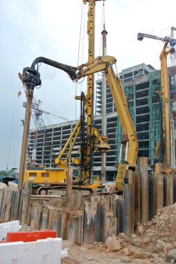 SELANGOR, MALAYSIA 12 Mart 2015: inşaat alanında çarşaf yığını cofferdam sürücü makine. Bu makine titreşimli hidrolik kol kullanarak çarşaf yığınını yere itti. İşçi kontrolü. 