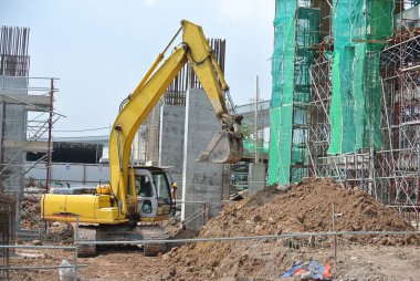 SELANGOR, MALAYSIA -HAZİRAN 02, 2016: Kazı makinesi inşaat alanında toprak kazılarında kullanılan ağır bir inşaat makinesidir. Uzun hidrolik bir kolla sepetle güçlendirilmiş. İşçiler tarafından işletilen.