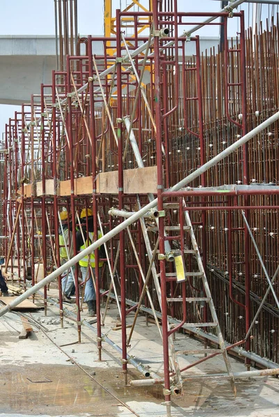 マレーシア セランゴール州 2016年2月23日 マレーシア セランゴールの建設現場に安全ハーネスを装着し 足場を高いレベルで設置する建設労働者 — ストック写真