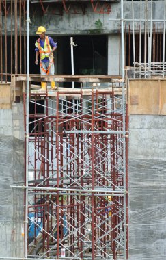 SELANGOR, MALAYSIA -23 Şubat 2016: Selangor, Malezya 'daki inşaat sahasında emniyet kemeri takan ve iskele döşeyen inşaat işçileri.