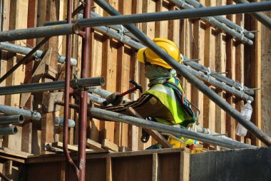 SELANGOR, MALAYSIA - 23 Şubat 2016: Emniyet kemeri takan ve Malezya 'nın Selangor kentindeki şantiyede yüksek seviyede çalışan inşaat işçileri.