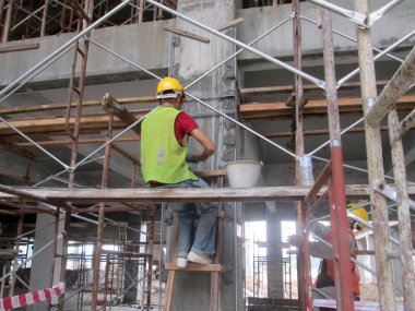 SERDANG, MALAYSIA - 25 Temmuz 2017: İnşaat işçileri inşaat alanında çimento, kum ve kireç karışımı ile inşaat duvarı ve kiriş sıva kullanarak inşaat işçileri.