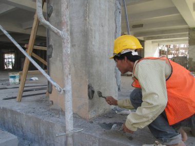SERDANG, MALAYSIA - 25 Temmuz 2017: İnşaat işçileri inşaat alanında çimento, kum ve kireç karışımı ile inşaat duvarı ve kiriş sıva kullanarak inşaat işçileri.