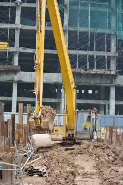 SELANGOR, MALAYSIA -HAZİRAN 02, 2016: Kazı makinesi inşaat alanında toprak kazılarında kullanılan ağır bir inşaat makinesidir. Uzun hidrolik bir kolla sepetle güçlendirilmiş. İşçiler tarafından işletilen.