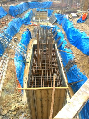 JOHOR, MALAYSIA -16 HAZİRAN 2015: Yığınla takviye çubuğu ve Johor, Malezya 'daki inşaat alanında kazılan kazılar. 