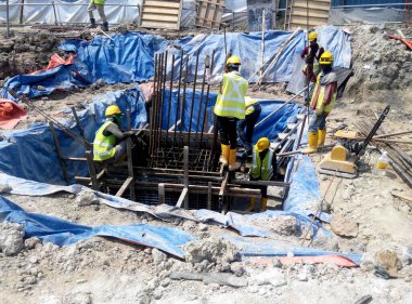 JOHOR, MALAYSIA -16 HAZİRAN 2015: Yığınla takviye çubuğu ve Johor, Malezya 'daki inşaat alanında kazılan kazılar. 