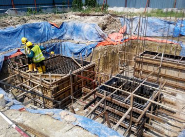 JOHOR, MALAYSIA -16 HAZİRAN 2015: Yığınla takviye çubuğu ve Johor, Malezya 'daki inşaat alanında kazılan kazılar. 