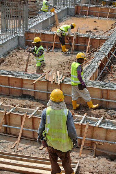 JOHOR, MALAYSIA -APRIL 14, 2016: Group of construction workers working at the construction site at Johor, Malaysia during daytime.  