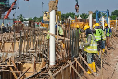 MALACCA, MALAYSIA -ECTOBER 13, 2015: Malacca, Malezya 'da inşaat alanında çelik takviye barı üreten inşaat işçileri. Destek çubuğu küçük kabloyla birbirine bağlanmıştı..  
