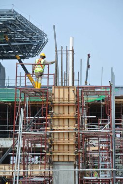 MALACCA, MALAYSIA - 25 Mart 2016: Malacca, Malezya 'daki şantiyede kiriş ve sütun biçiminde kereste üreten inşaat işçileri ve takviye barı.