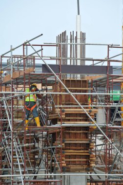 MALACCA, MALAYSIA - 25 Mart 2016: Malacca, Malezya 'daki şantiyede kiriş ve sütun biçiminde kereste üreten inşaat işçileri ve takviye barı.